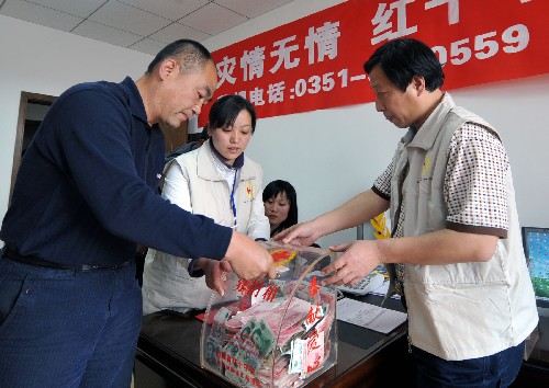 5月13日,太原市民在山西省紅十字會(huì)捐款。當(dāng)日,山西群眾踴躍為汶川地震災(zāi)區(qū)群眾捐款獻(xiàn)血,表達(dá)對(duì)災(zāi)區(qū)的支援。截至13日16時(shí),山西省紅十字會(huì)已經(jīng)收到來自社會(huì)各界的270多萬元捐款和價(jià)值300萬元的藥品。 新華社記者燕雁攝