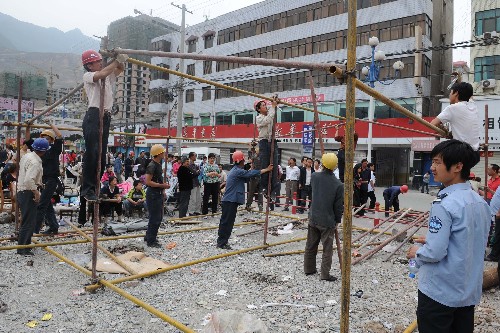 5月13日,在甘肅省隴南市武都區(qū)一廣場(chǎng),工作人員在為受災(zāi)群眾搭建簡(jiǎn)易帳篷。 受汶川地震影響,甘肅隴南9縣區(qū)均有強(qiáng)烈震感,并造成嚴(yán)重人員傷亡和財(cái)產(chǎn)損失。目前,隴南市各項(xiàng)抗震救災(zāi)工作正在有序進(jìn)行。 新華社記者 韓傳號(hào) 攝