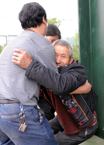 5月13日,在四川綿竹縣的一處臨時救援中心,一位男青年在扶助一位受傷的老人。 新華社記者 李曉果 攝