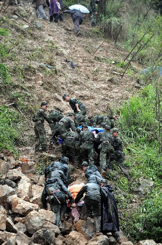5月13日,救災(zāi)官兵將受重傷的群眾抬到安全地帶。地震造成四川北川縣老縣城80%、新縣城60%以上建筑垮塌,地震引發(fā)的山體滑坡讓縣城幾乎成為一片廢墟。 新華社記者楊磊攝