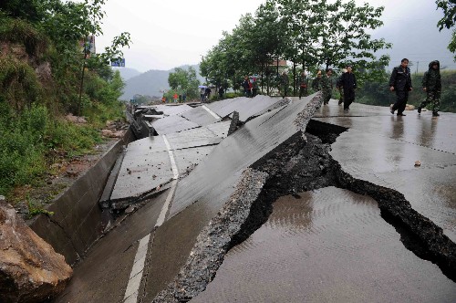 5月13日,北川縣城外公路多處塌陷和拱起,交通阻斷。地震造成四川北川縣老縣城80%、新縣城60%以上建筑垮塌,地震引發(fā)的山體滑坡讓縣城幾乎成為一片廢墟。 新華社記者楊磊攝