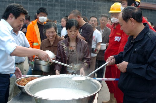 四川綿竹設(shè)立救助點(diǎn)為災(zāi)民提供熱稀飯 新華社照片,綿竹,2008年5月15日 四川綿竹設(shè)立救助點(diǎn)為災(zāi)民提供熱稀飯 5月15日,工作人員正在為災(zāi)民盛稀飯。 四川汶川地震造成綿竹災(zāi)區(qū)大量群眾無(wú)家可歸。目前僅綿竹市區(qū)就有10多萬(wàn)人居住在臨時(shí)搭建的帳篷內(nèi),大多數(shù)人自地震以來(lái)就沒(méi)吃上過(guò)一頓熱飯。為解決災(zāi)民的困難,綿竹市委市政府從15日起在城區(qū)的居民聚居點(diǎn)設(shè)立6個(gè)臨時(shí)就餐點(diǎn),免費(fèi)為災(zāi)民供應(yīng)熱稀飯和菜。 新華社記者 苑堅(jiān) 攝