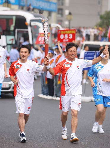 5月31日,火炬手、跳水奧運(yùn)冠軍肖海亮(左)與火炬手、曾經(jīng)培養(yǎng)出奧運(yùn)冠軍的父親肖愛(ài)山一起傳遞。當(dāng)日,北京奧運(yùn)會(huì)圣火在湖北武漢傳遞。 新華社記者邢廣利攝