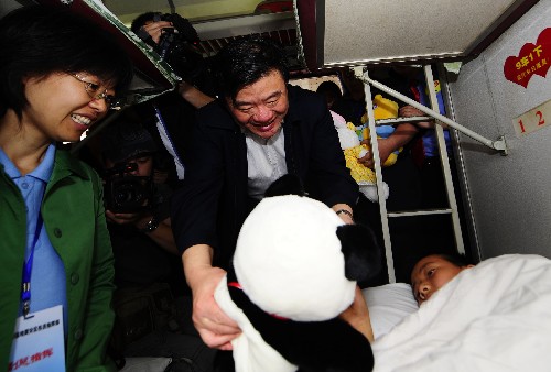 5月31日,衛(wèi)生部部長陳竺(中)在運送傷員的專列上向四川都江堰地震傷員、13歲的彭磊贈送兒童節(jié)禮物。 據(jù)衛(wèi)生部介紹,從5月17日至31日,全國各省區(qū)出動醫(yī)務(wù)人員5000余人,通過21次專列、99架包機(jī)以及萬余次救護(hù)車的運送,從四川地震災(zāi)區(qū)向北京、天津、遼寧、浙江等20個?。ㄊ?、自治區(qū))340多家三級醫(yī)院轉(zhuǎn)送地震傷員近萬名,為最大限度改善地震傷員治療條件、保護(hù)傷員健康創(chuàng)造了有利條件。 新華社記者 任勇 攝