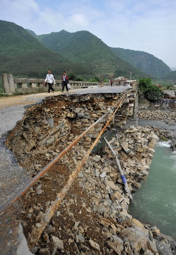 5月31日,幾位村民從被洪水沖毀的望謨縣新屯大橋上走過。 受連日強(qiáng)降雨影響,貴州省的西部和南部遭受特大洪水與泥石流襲擊,損失嚴(yán)重。目前,各級政府已調(diào)集2萬余人的搶險(xiǎn)隊(duì)伍有序展開搶險(xiǎn)救災(zāi)工作。 新華社記者楊俊江攝