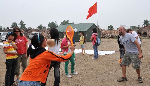 5月31日,天河海軍小學(xué)的一名學(xué)生在操場(chǎng)上與加拿大的志愿者打羽毛球。 “六一”兒童節(jié)來(lái)臨之際,四川省綿竹市東北鎮(zhèn)天河海軍小學(xué)的學(xué)生以積極樂(lè)觀的態(tài)度迎接自己的節(jié)日。 新華社記者 郝同前攝