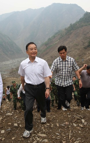 6月6日,中共中央政治局常委、國務院總理、國務院抗震救災總指揮部總指揮溫家寶繼續(xù)在綿陽考察唐家山堰塞湖除險工作,看望部分轉(zhuǎn)移安置群眾和參加唐家山堰塞湖搶險工作的武警水電部隊官兵、水利專家,要求按照安全、科學、快速的原則,采取果斷措施,盡快解除唐家山堰塞湖的威脅。這是溫家寶再次實地察看堰塞湖后,頂著螺旋槳產(chǎn)生的巨大氣流艱難地靠近直升機,準備返回綿陽。 新華社記者劉衛(wèi)兵攝