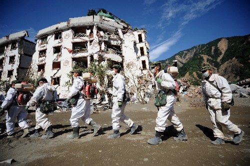 成都軍區(qū)駐滇某部防化團(tuán)防化兵對北川縣城地震廢墟進(jìn)行例行防疫處理(7月5日攝)。“舍不得??!”一位從安置點回自家廢墟取石材切割機準(zhǔn)備外出務(wù)工的北川縣城居民說。這是7月5日新華社記者被特許進(jìn)入北川縣城采訪時聽到北川人說的第一句話。 走進(jìn)震后的北川縣城,感覺這里仿佛被超人的力量按了“暫停”——一棟棟倒塌的房屋,一瓶瓶沒用完的洗發(fā)水、一本本散落的時尚雜志、晾干了沒被收起的衣服、裝修好沒來得及入住的新房……這一切被定格在了廢墟上。 走在北川縣城,不需要言語,從防化痕跡就能看懂哪里曾經(jīng)有一個鮮活的生命逝去,從扭曲的樓房和巨型的山石就能想像人們在地震的剎那間面對著多么慘烈的場面,從隨處散落的牛奶盒、沙發(fā)、電視機、電腦、相冊等就能知道這里的人曾經(jīng)過著怎樣的生活。 走在北川縣城,偶爾遇到當(dāng)?shù)鼐用?,不敢問他們親人是否都在,怕觸動了傷心的魂;也不想說些“加油”之類的話,因為這些話在此時此地顯得那么蒼白無力。 走在北川縣城,街道兩邊的樹上不時傳來陣陣蟬鳴,幼苗從堰塞湖水沖出的淤泥中長出,廢墟中的鐘表還在“滴答滴答”計量著時間的腳步,街頭還有幸存的雞鴨在覓食,防化兵在細(xì)致地噴灑著藥物,遭受重創(chuàng)的北川依然蘊含著不