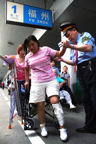 7月11日,在福州火車站,一名來閩治療的傷員在列車長和志愿者的幫助下,準(zhǔn)備登車返鄉(xiāng)。當(dāng)日,在福建接受治療的一批四川地震災(zāi)區(qū)傷員及家屬20余人乘列車返回四川。這批傷員及家屬自5月起先后被安排至福州、泉州的醫(yī)院接受治療。目前,除有部分重傷員在閩繼續(xù)接受治療外,其余傷員已陸續(xù)返鄉(xiāng)。 新華社發(fā)(鄭帥 攝)