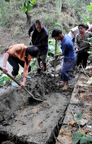 10日,在貴州省荔波縣茂蘭鎮(zhèn)羅家寨村,當?shù)氐霓r(nóng)民正在清理被洪水沖毀的溝渠。