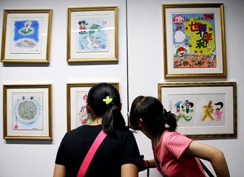 8月15日,參觀者在侵華日軍南京大屠殺遇難同胞紀念館觀看展出的漫畫作品。