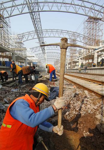 月12日,建筑工人在合肥火車站站場(chǎng)里施工。 由中鐵四局承建、投資近5億元的合肥火車站改造工程主體工程之一的站房改造工程近日基本完工,將于1月28日投入使用,以應(yīng)對(duì)春運(yùn)期間激增的客流,方便旅客出行。新站房包括候車室和售票大廳,建成后建筑面積將擴(kuò)大6000多平方米,并增加了多部電梯。 新華社記者李健攝