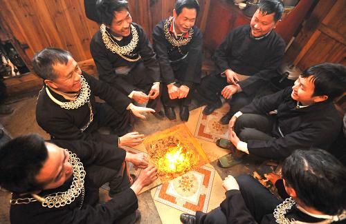 1月13日,危改戶、苗族同胞張里九(右三)在新居內(nèi)與村民圍爐而坐,共慶遷入新居。