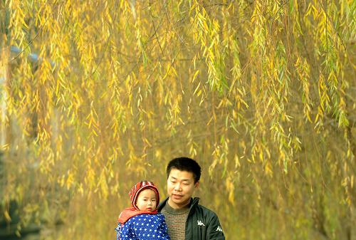 1月14日,一位市民抱著小孩,在云陽(yáng)縣濱江公園游玩。新華社記者 李曉果 攝