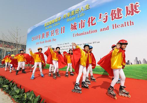 4月7日,來自芳草地國(guó)際學(xué)校的小朋友們?cè)谶M(jìn)行輪滑表演。 當(dāng)日是世界衛(wèi)生日。由衛(wèi)生部、全國(guó)愛衛(wèi)辦和北京市政府等聯(lián)合主辦的2010年世界衛(wèi)生日紀(jì)念活動(dòng)在北京奧運(yùn)景觀大道啟動(dòng)。今年世界衛(wèi)生日聚焦“城市化與健康”,旨在倡導(dǎo)人們關(guān)注城市化給全球公共衛(wèi)生和個(gè)人健康帶來的影響。紀(jì)念活動(dòng)現(xiàn)場(chǎng)有民間團(tuán)體帶來的太極扇、健步走等多項(xiàng)表演內(nèi)容。 新華社記者何俊昌攝