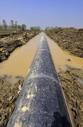 成功穿越河道的大管徑輸氣管道(4月8日攝)。 4月8日,西氣東輸二線東段倒水河定向鉆穿越工程完工,這段工程位于湖北省武漢市新洲區(qū)境內(nèi),河底多為巖石層或卵礫石地層,硬度高,難度大。負(fù)責(zé)施工的天津世紀(jì)東大管道穿越工程公司采用目前世界最大拉力和扭力的水平定向鉆機(jī)施工,自今年1月14日開工以來,用3個(gè)月時(shí)間成功貫通。 新華社記者 程敏 攝