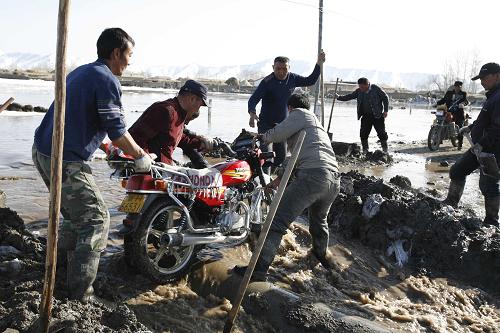 4月27日,新疆阿勒泰富蘊(yùn)縣吐爾洪鄉(xiāng)道路被洪水沖斷,抗洪應(yīng)急救援小分隊(duì)人員幫助村民將摩托車推過危險(xiǎn)路段。 當(dāng)日,新疆阿勒泰地區(qū)富蘊(yùn)縣局部地區(qū)遭遇不同程度的融雪性洪水。洪水造成200余畝耕地被淹,17戶房屋受損、2戶倒塌。洪水發(fā)生后,當(dāng)?shù)剡叿牢渚俦?、民兵和機(jī)關(guān)干部迅速組成應(yīng)急救援分隊(duì),緊急轉(zhuǎn)移受災(zāi)群眾,相關(guān)部門調(diào)運(yùn)1萬條防洪袋對居民區(qū)及重要地段進(jìn)行攔護(hù),并及時(shí)出動(dòng)機(jī)械對公路積水進(jìn)行引水泄洪,確保道路暢通。截至目前,洪水險(xiǎn)情已得到控制,無人員傷亡報(bào)告。 新華社發(fā)(丁寧 攝)