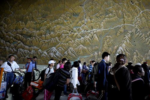 7月1日,旅客從拉薩火車站候車大廳的青藏鐵路路線圖前走過(guò)。 2006年7月1日青藏鐵路全線通車。四年來(lái),青藏鐵路運(yùn)行安全平穩(wěn),這條被稱為“天路”的高原鐵路強(qiáng)力助推著青藏高原社會(huì)經(jīng)濟(jì)發(fā)展,成為西部大開發(fā)中的大動(dòng)脈。 新華社記者 普布扎西攝