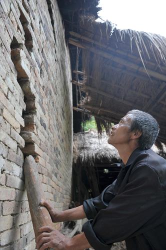 7月2日,在廣西凌云縣沙里瑤族鄉(xiāng)果卜村,一名村民用木棍頂住房屋開(kāi)裂的墻體。 6月27日至30日,受高空槽氣流東移影響,廣西凌云縣遭遇自1958年有氣象資料記載以來(lái)最強(qiáng)的降雨天氣過(guò)程。據(jù)最新統(tǒng)計(jì),凌云縣因暴雨引發(fā)33處泥石流、山體滑坡和巖石坍塌等地質(zhì)災(zāi)害,已緊急轉(zhuǎn)移受災(zāi)群眾1439人。 新華社記者 周華 攝