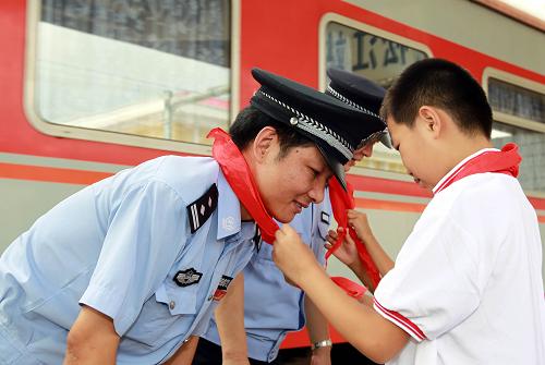 8月10日,上海松江南二村小學(xué)的學(xué)生為他們的校外安全輔導(dǎo)員、上海鐵路公安民警張慧系紅領(lǐng)巾。 當(dāng)日,上海鐵路公安處松江站的民警與滬杭高鐵沿線中小學(xué)校師生共同開展的“和我一起護(hù)高鐵”安全教育宣傳活動(dòng)正式啟動(dòng)。民警們將深入到沿線學(xué)校、村鎮(zhèn)街道、農(nóng)貿(mào)市場、工地以及外來人員聚集地,宣傳維護(hù)高鐵運(yùn)行安全知識(shí),增強(qiáng)群眾的安全意識(shí)。即將于今年10月1日通車的滬杭高速鐵路客運(yùn)線,在上海境內(nèi)有50多公里,沿線有70余萬人,中小學(xué)校12所,在校學(xué)生7000余人。 新華社記者 任瓏 攝
