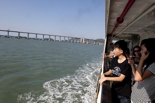 在由平潭駛往福清的輪渡上,乘客在觀看海峽大橋雄姿(8月12日攝)。 全長4976米、總投資逾11億元的跨海大橋——福建平潭海峽大橋自2007年11月開工建設(shè)以來,目前已完成施工總產(chǎn)值超過90%,進(jìn)入最后合龍沖刺階段,計(jì)劃于2011年元旦前建成通車。平潭海峽大橋是福建第一大島——平潭島的首條出島快捷通道,大橋的建成將結(jié)束該島40萬居民長期依靠輪渡往來的歷史。 新華社記者姜克紅攝