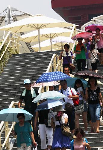 8月13日,游客在高溫中游覽世博園。 當(dāng)日12時(shí)33分,上海中心氣象臺(tái)、世博氣象臺(tái)更新世博園區(qū)高溫橙色預(yù)警信號(hào)為高溫紅色預(yù)警信號(hào),提醒游客做好防暑降溫工作,合理安排參觀活動(dòng)。下午2點(diǎn)園區(qū)的最高溫度已經(jīng)達(dá)到40.7℃。 新華社記者汪永基攝