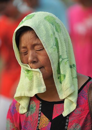 8月13日,在上海世博園內(nèi),一位游客將毛巾蓋在頭上避暑。 當(dāng)日12時(shí)33分,上海中心氣象臺(tái)、世博氣象臺(tái)更新世博園區(qū)高溫橙色預(yù)警信號(hào)為高溫紅色預(yù)警信號(hào),提醒游客做好防暑降溫工作,合理安排參觀活動(dòng)。下午兩點(diǎn)園區(qū)的最高溫度已經(jīng)達(dá)到40.7℃。 新華社記者丁海濤攝