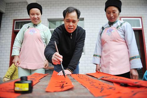 2月13日,布依族同胞寫春聯(lián)、迎新年。當(dāng)日,在貴陽市花溪區(qū)馬鈴鄉(xiāng)的水車壩布依寨里,布依族同胞們家家戶戶寫對聯(lián)、貼窗花、唱山歌,舉行新年“開門”儀式,迎接虎年春節(jié)的到來。新華社記者 歐東衢 攝
