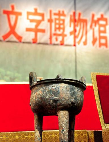 擺放在河南省文物征調(diào)入藏儀式現(xiàn)場(chǎng)的一件刻有銘文的青銅器(7月14日攝)。7月14日,河南省征調(diào)文物入藏中國(guó)文字博物館儀式在河南省博物院舉行。193件有關(guān)文字的珍貴文物被移交中國(guó)文字博物館收藏。這批移交的文物包括河南博物院院藏“十六年鄭令”戈、銅“部曲將”印、曾子甗等123件文物和河南省文物考古研究所所藏的賈湖龜腹甲刻符、新蔡葛陵楚墓竹簡(jiǎn)、溫縣盟書、長(zhǎng)子口鼎、薳子昃鼎、平夜君成戈、垂球等不同歷史時(shí)期的各門類文物70件。中國(guó)文字博物館位于甲骨文的故鄉(xiāng)河南省安陽(yáng)市,是經(jīng)國(guó)務(wù)院批準(zhǔn)的國(guó)家級(jí)專題博物館,一期工程將于年內(nèi)對(duì)外開放。新華社記者 王頌 攝