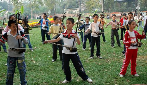 10月6日,孩子們在河南省安陽市人民公園里學(xué)習(xí)二胡演奏。 國慶長假期間,親近自然的鄉(xiāng)村游和各種休閑娛樂活動成為人們鐘情的度假方式,“放松”、“愜意”、“開心”正成為長假旅游的關(guān)鍵詞。新華社發(fā)(張志勇 攝)