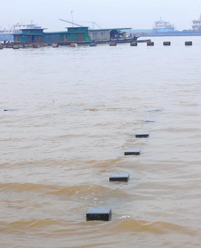 6月27日,岳陽(yáng)洞庭湖邊環(huán)湖步行道被湖水淹沒(méi),僅露出護(hù)欄的頂端。新華社記者 龍弘濤 攝