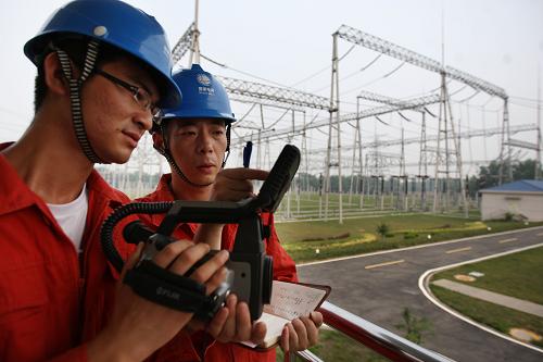 7月5日,安徽省淮北供電公司員工在變電站用紅外測溫儀器對電網(wǎng)進行檢測。新華社發(fā)(王文 攝)