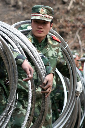 2月16日,武警戰(zhàn)士正在建寧山區(qū)往山頂運送電線。新華社發(fā)(黃躍斌 攝)