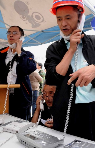5月17日,幾位都江堰災(zāi)民用免費(fèi)電話(huà)與外界聯(lián)系。目前,都江堰暫未恢復(fù)供電,許多災(zāi)民仍居住在臨時(shí)帳篷里,但在政府和社會(huì)各界的援助下,災(zāi)區(qū)人民的生活基本得到保證。 新華社記者楊楹攝
