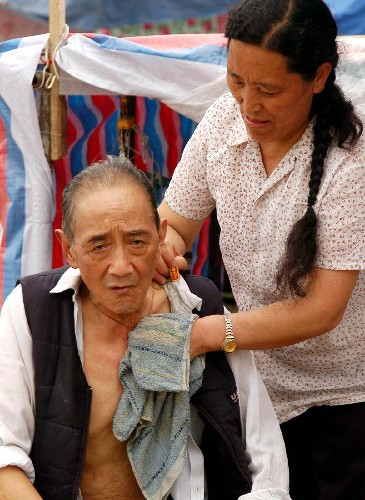 5月17日,在都江堰一個(gè)災(zāi)民安置區(qū),一位婦女正在為一位老人擦拭身體。目前,都江堰暫未恢復(fù)供電,許多災(zāi)民仍居住在臨時(shí)帳篷里,但在政府和社會(huì)各界的援助下,災(zāi)區(qū)人民的生活基本得到保證。 新華社記者楊楹攝