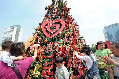 5月17日,在杭州舉行的“幫助地震災(zāi)區(qū)孤兒度過(guò)難關(guān)”援孤計(jì)劃啟動(dòng)現(xiàn)場(chǎng),幾名孩子和家長(zhǎng)們正在往祈愿樹(shù)上擺放一只只滿(mǎn)懷祝福的千紙鶴。這棵6米多高的祈愿樹(shù)上已綴滿(mǎn)了近十萬(wàn)只千紙鶴。當(dāng)日上午,由浙江省愛(ài)心事業(yè)基金會(huì)和杭州千名“陽(yáng)光義工”共同發(fā)起的“幫助地震災(zāi)區(qū)孤兒渡過(guò)難關(guān)”援孤計(jì)劃在杭州啟動(dòng)。該計(jì)劃將通過(guò)四川省相關(guān)部門(mén)收集部分災(zāi)后孤兒的信息資料,把“援孤愛(ài)心基金”用于孤兒們今后的生活、學(xué)習(xí),讓這份愛(ài)心伴隨他們的成長(zhǎng)歷程。 新華社發(fā)(李忠 攝)