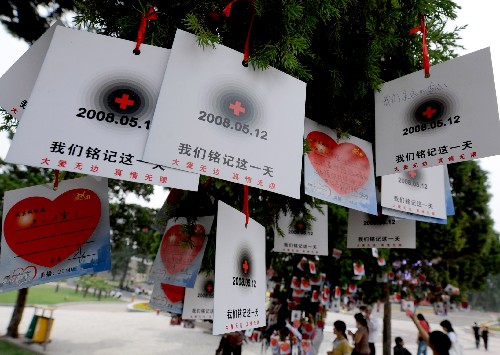5月21日,在河南省鄭州市街頭一個(gè)廣場(chǎng)上,許多市民在“愛(ài)心”牌上寫下對(duì)災(zāi)區(qū)群眾的祝福話語(yǔ)。 新華社記者朱祥攝