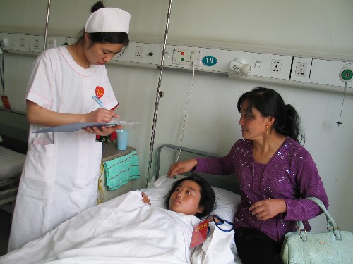 5月21日,西京醫(yī)院的醫(yī)護人員正在了解來自北川縣的16歲羌族女孩張永芳的病情。 當日6時58分,載著248名四川地震災區(qū)重傷員的專列抵達西安火車站,這批傷員被迅速轉(zhuǎn)運到西京醫(yī)院和唐都醫(yī)院。這是汶川地震發(fā)生后被送往陜西省進行救治的首批重傷員。 新華社記者許祖華攝