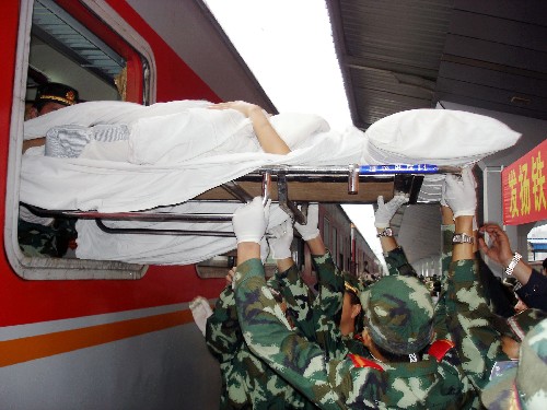 5月22日,武警戰(zhàn)士把一名傷員從專列上抬出。 當日,一列搭載著汶川大地震災區(qū)300名傷員的專列抵達貴州省遵義市,其中100名傷員將在遵義醫(yī)學院附屬醫(yī)院接受治療,他們中年齡最大的83歲,最小的僅7個月大。 新華社發(fā)(王鴻 攝)