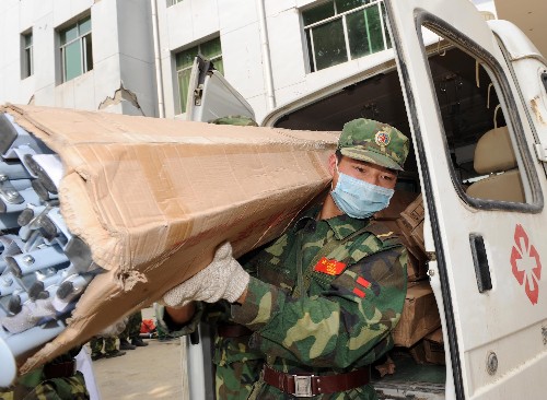 5月22日,在四川省青川縣,一名解放軍戰(zhàn)士在搬運外地運來的帳篷。 連日來,全國各地送來的救災物資陸續(xù)運抵四川汶川地震重災區(qū)之一的青川縣,目前當?shù)卣泳o組織發(fā)放,確保救災物資及時送到災區(qū)群眾手中。 新華社記者 藺以光 攝