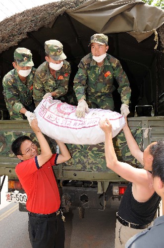 5月22日,在四川省青川縣,解放軍戰(zhàn)士在向災區(qū)群眾發(fā)放外地運來的救災物資。 連日來,全國各地送來的救災物資陸續(xù)運抵四川汶川地震重災區(qū)之一的青川縣,目前當?shù)卣泳o組織發(fā)放,確保救災物資及時送到災區(qū)群眾手中。 新華社記者 藺以光 攝