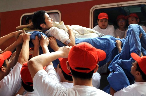 5月27日,在石家莊火車站,工作人員將傷員抬下列車。 當(dāng)日,160名四川地震災(zāi)區(qū)傷員在其家屬和醫(yī)護(hù)人員陪護(hù)下,乘坐北京鐵路局運送地震傷員的專列分別轉(zhuǎn)至石家莊市和天津市各大醫(yī)院進(jìn)行治療。 新華社記者 唐召明 攝