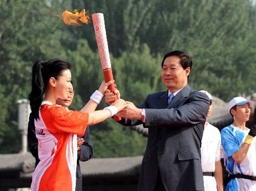 6月26日,奧運火炬譚晶(左)從山西省委書記張寶順手中接過點燃的火炬。當(dāng)日,北京奧運圣火在山西太原傳遞。 新華社記者 燕雁 攝