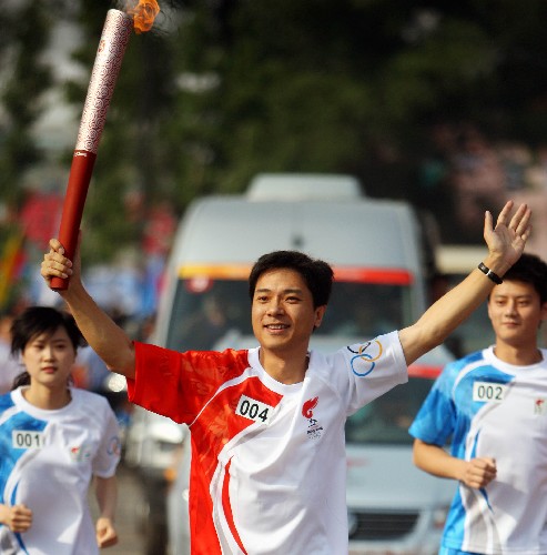 6月26日,奧運火炬手李彥宏手持火炬?zhèn)鬟f。當(dāng)日,北京奧運圣火在山西太原傳遞。 新華社記者 邢廣利 攝