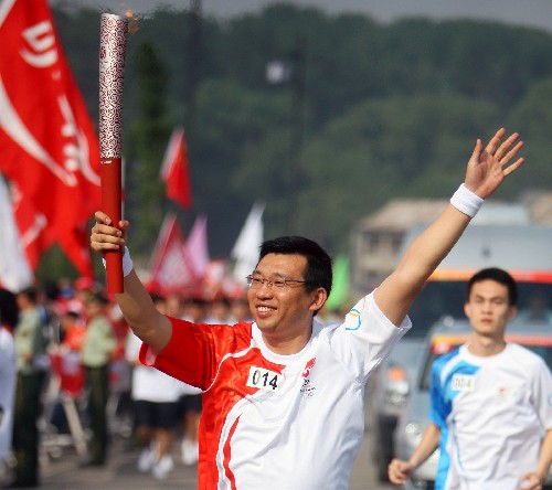 6月26日,奧運火炬手朱健手持火炬?zhèn)鬟f。當(dāng)日,北京奧運圣火在山西太原傳遞。 新華社記者邢廣利攝