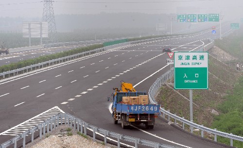 7月2日,一輛施工車輛從梅廠村入口進入京津高速公路。目前,京津高速公路主線道路工程、橋梁工程,以及服務(wù)區(qū)、收費站和停車區(qū)主體也已完工,即將實現(xiàn)全線通車。京津高速公路3年前開工建設(shè),北起北京朝陽區(qū)西直河,終點到達天津塘沽區(qū),全長184.4公里。 新華社記者王曄彪攝