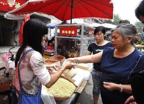 7月2日,都江堰市的受災(zāi)群眾在購買食物。 商貿(mào)流通直接關(guān)系到老百姓日用品的供應(yīng)。記者日前走訪了四川各災(zāi)區(qū)安置點(diǎn)和政府相關(guān)部門,了解災(zāi)區(qū)群眾的日常生活用品供應(yīng)情況。四川省商務(wù)廳的統(tǒng)計(jì)顯示,目前災(zāi)區(qū)商貿(mào)流通經(jīng)營(yíng)網(wǎng)點(diǎn)已恢復(fù)九成。 新華社記者 章磊 攝