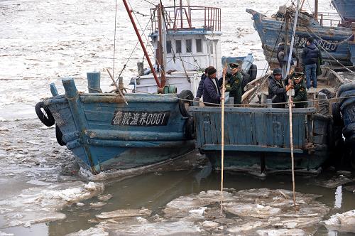 1月10日,青島營(yíng)海邊防派出所民警在幫助被困漁船返港。新華社記者 李紫恒 攝