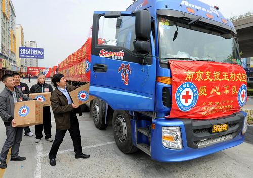 4月25日,送米車隊(duì)發(fā)車前,孫達(dá)華(右一)在搬運(yùn)隨車帶往災(zāi)區(qū)的捐贈(zèng)食品。當(dāng)日,在南京正大茶城開展的“情系玉樹,大愛無(wú)疆”現(xiàn)場(chǎng)捐贈(zèng)活動(dòng)中,江蘇盱眙縣糧食生產(chǎn)經(jīng)營(yíng)大戶孫達(dá)華向玉樹地震災(zāi)區(qū)捐贈(zèng)了100噸大米,并捐款近24萬(wàn)元。捐贈(zèng)儀式結(jié)束后,孫達(dá)華帶著車隊(duì)將大米送往災(zāi)區(qū)。新華社記者 孫參 攝