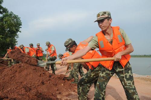 7月20日,武警江西總隊官兵在鄱陽縣昌江圩堤處理崩岸險情。當日,江西省鄱陽縣昌江圩堤龍坑段發(fā)生約180米迎水面崩岸險情,武警江西總隊100余名官兵火速馳援。經(jīng)過數(shù)小時的奮戰(zhàn),目前險情已基本得到控制。7月19日開始,昌江水位逐步下降,長時間被高水位浸泡的圩堤迎水面在退水的吸力下,土石干裂脫落,堤壩基腳不穩(wěn),極易引發(fā)崩岸險情。新華社發(fā)(謝析搏攝)